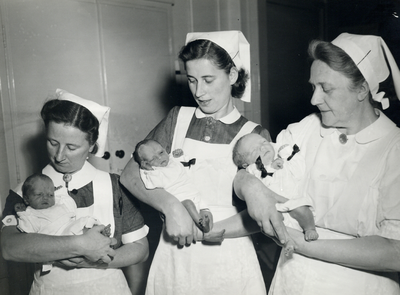 405216 Afbeelding van drie zusters van het Stads- en Academisch Ziekenhuis (Catharijnesingel 101) met de pasgeboren ...